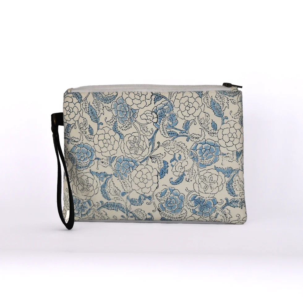 Pochette artigianale in cotone con motivi floreali azzurri su fondo bianco indiani e manico pratico in ecopelle.